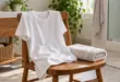 Ein helles T-Shirt und ein Handtuch auf einem Holzstuhl im Badezimmer